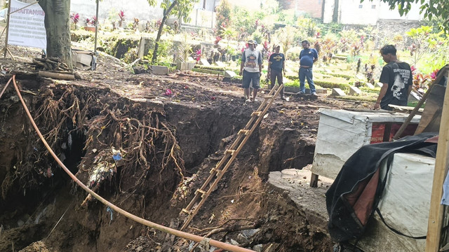 Tembok penahan tanah (TPT) yang longsor diperbaiki di TPU Nagrog, Kecamatan Ujungberung, Selasa (11/3/2025). Foto: Robby Bouceu/kumparan
