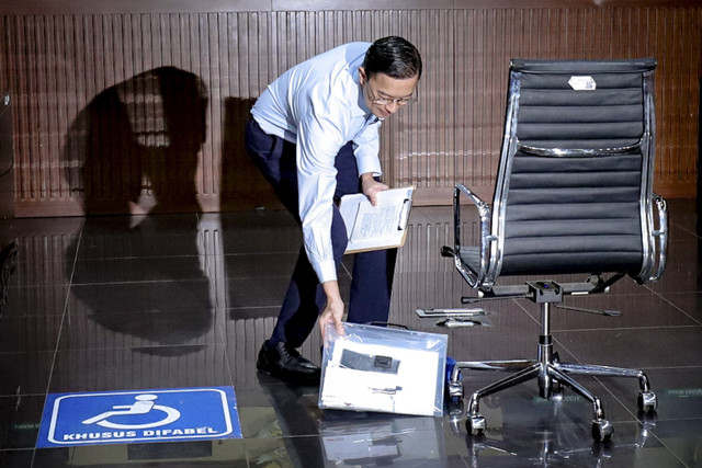 Terdakwa kasus dugaan korupsi impor gula Thomas Lembong mengambil berkas saat menjalani sidang eksepsi di Pengadilan Tidak Pidana Korupsi, Jakarta, Kamis (13/3/2025). Foto: Jamal Ramadhan/kumparan