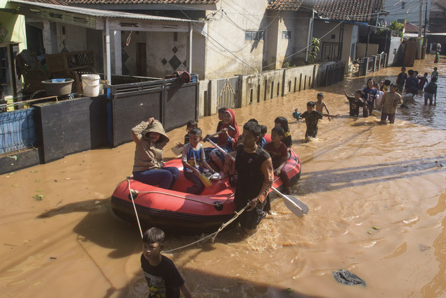 Warga menggunakan perahu saat melintasi banjir di Desa Cihanjuang, Cimanggung, Sumedang, Jawa Barat, Jumat (14/3/2025). Foto: Novrian Arbi/ANTARA FOTO