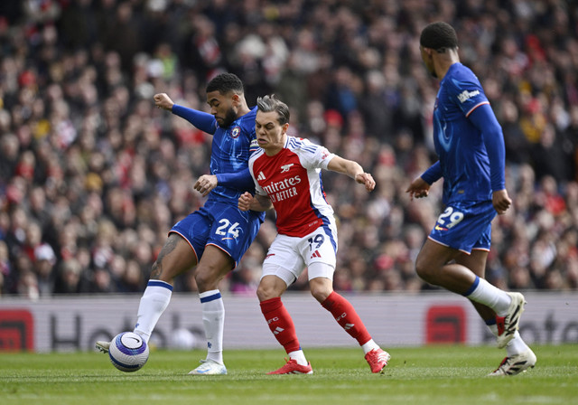 Pemain Chelsea Reece James beraksi dengan pemain Arsenal Leandro Trossard pada pertandingan Liga Inggris antara Arsenal vs Chelsea di Stadion Emirates, London, Inggris, Minggu (16/3/2025). Foto: Tony O Brien/REUTERS