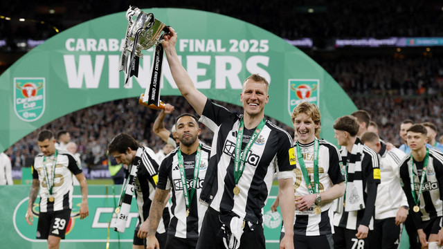 Pemain Newcastle United, Dan Burn, genggam trofi juara Piala Liga Inggris 2024/25 di Stadion Wembley, Senin (17/3) dini hari WIB. Foto: Action Images via Reuters/Andrew Couldridge