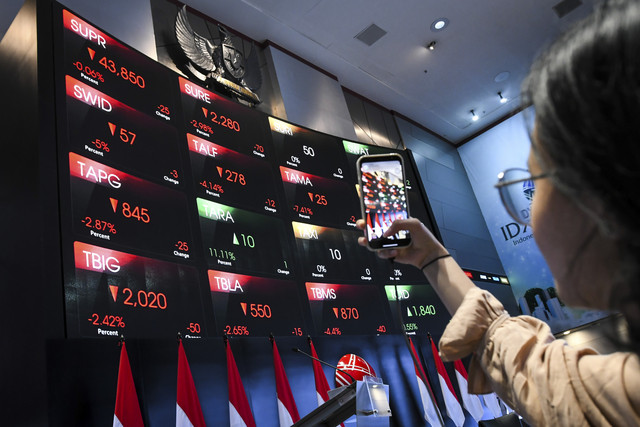 Warga memantau pergerakan saham melalui gawainya di Bursa Efek Indonesia, Jakarta, Selasa (18/3/2025). Foto: Sulthony Hasanuddin/ANTARA FOTO