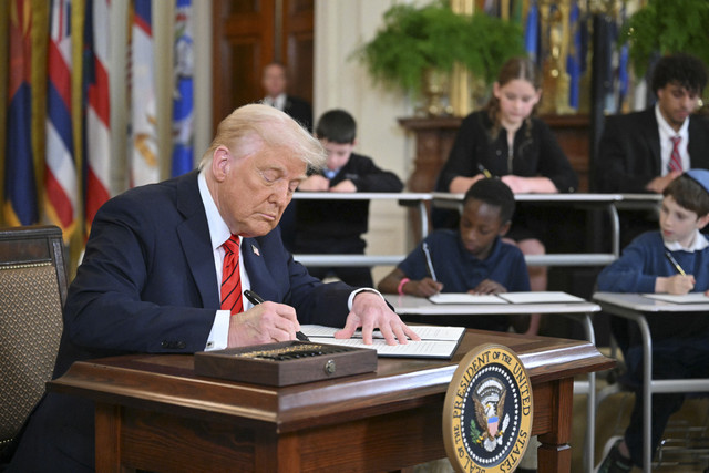 Presiden AS Donald Trump melakukan tanda tangan perintah esekutif di Gedung Putih, Washington DC, Amerika Serikat, Kamis (20/3/2025). Foto: Mandel Ngan/AFP
