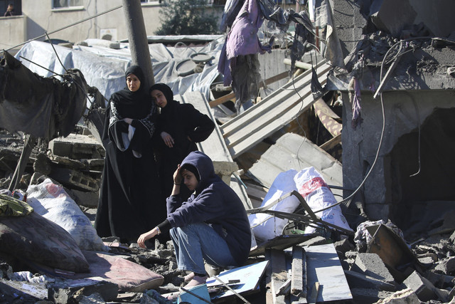 Warga Palestina bereaksi saat mereka memeriksa puing-puing dan reruntuhan di lokasi serangan Israel pada malam sebelumnya di kamp pengungsi Nuseirat di Jalur Gaza tengah, Minggu (23/3/2025). Foto: EYAD BABA/AFP