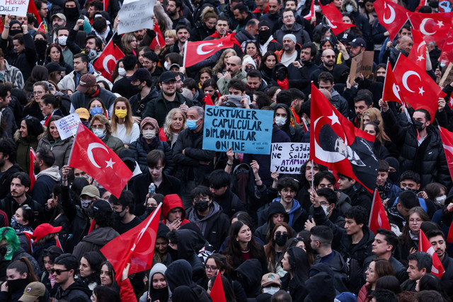Seorang pria memegang poster selama aksi protes pada hari Wali Kota Istanbul Ekrem Imamoglu dipenjara sebagai bagian dari penyelidikan korupsi di Istanbul, Turki, Minggu (23/3/2025). Foto: Dilara Senkaya/REUTERS