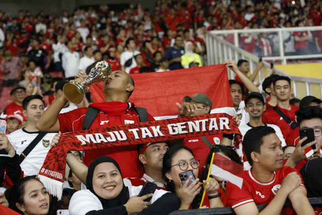 Seorang suporter Timnas Indonesia mencium replika trofi Piala Dunia pada pertandingan ronde ketiga Kualifikasi Piala Dunia 2026 zona Asia di Stadion Utama Gelora Bung Karno, Jakarta, Selasa (25/3/2025). Foto: Ajeng Dinar Ulfiana/Reuters
