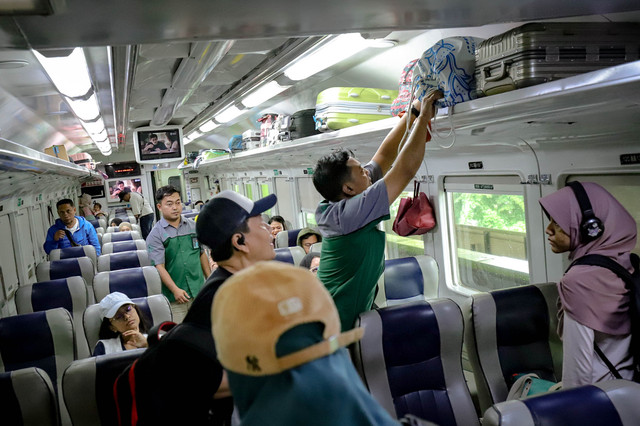Seorang penumpang meletakkan barang bawaan di gerbong kereta api di Stasiun Gambir, Jakarta, Rabu (26/3/2025). Foto: Jamal Ramadhan/kumparan