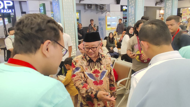 Menteri Pendidikan Dasar dan Menengah (Mendikdasmen) Abdul Mu'ti bersama Ketua Komisi X Hetifah Sjaifudian memberikan buku bacaan kepada para pemudik di Stasiun Pasar Senen, Jakarta Pusat, Rabu (26/3/2025). Foto: Alya Zahra/kumparan 