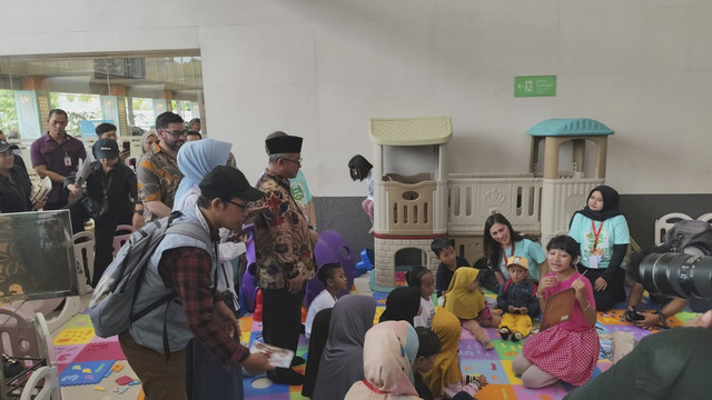Menteri Pendidikan Dasar dan Menengah (Mendikdasmen) Abdul Mu'ti bersama Ketua Komisi X Hetifah Sjaifudian memberikan buku bacaan kepada para pemudik di Stasiun Pasar Senen, Jakarta Pusat, Rabu (26/3/2025). Foto: Alya Zahra/kumparan 