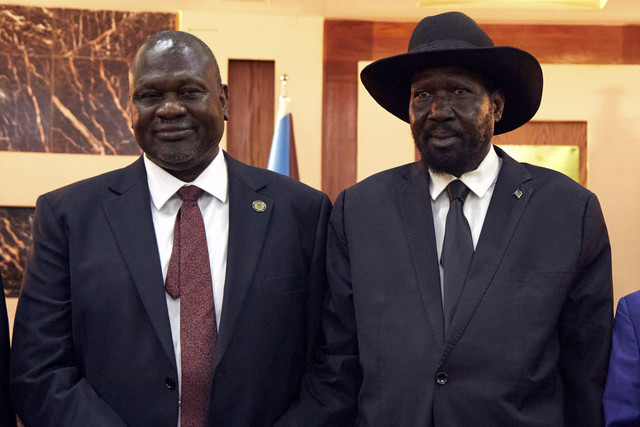 Presiden Sudan Selatan Salva Kiir (kanan) berdiri bersama Wakil Presiden Pertama Riek Machar. Foto: Alex McBride / AFP