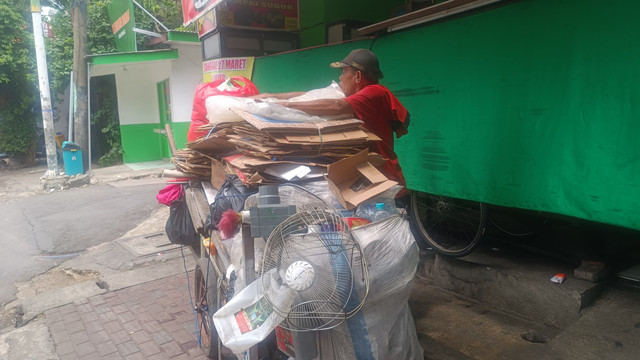 Jack (52) mengumpulkan barang bekas di kawasan Mampang, Jaksel, Jumat (28/3).  Foto: Thomas Bosco/kumparan