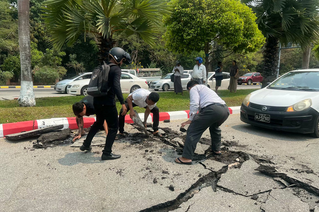 Warga membongkar jalan aspal yang rusak akibat gempa di Naypyidaw pada 28 Maret 2025. Foto: AFP