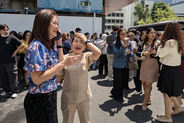 Orang-orang berdiri di luar gedung perkantoran di Bangkok pada tanggal 28 Maret 2025 setelah gempa bumi berkekuatan 7,7 skala Richter mengguncang Myanmar. Foto: Candida NG / AFP