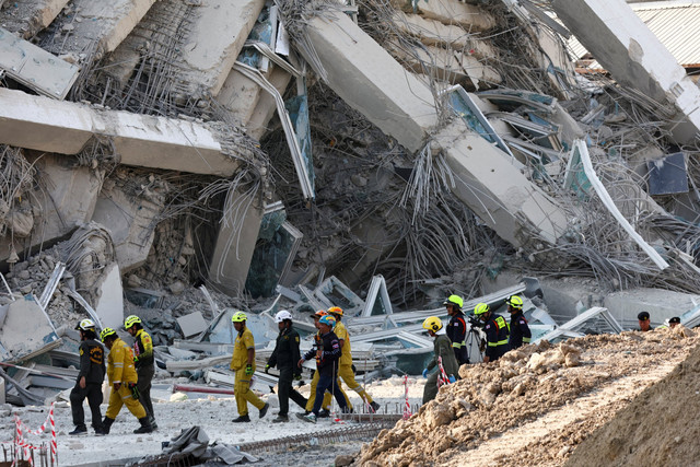 Tim penyelamat bersiap melakukan pencarian korban gedung ambruk akibat gempa di Bangkok, Thailand, Jumat (28/3/2025). Foto: Athit Perawongmetha/REUTERS