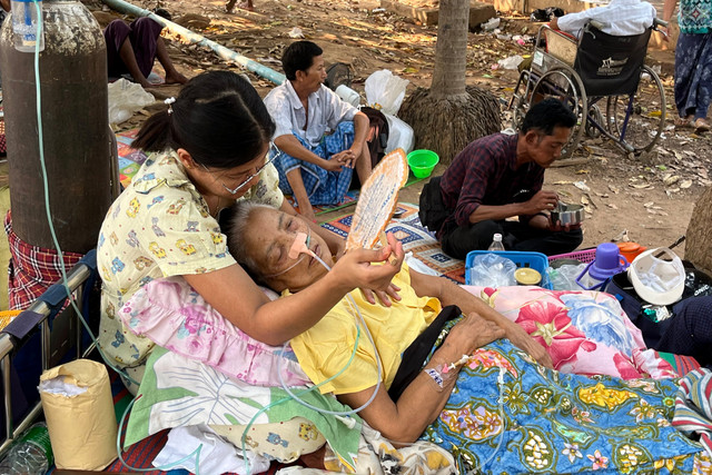 Warga korban gempa menerima perawatan medis di lantai kompleks rumah sakit di Naypyidaw, Myanmar, Jumat (28/3/2025). Foto: SEBASTIEN BERGER / AFP