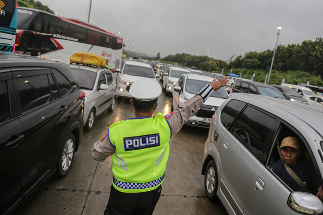 Anggota kepolisian mengatur arus lalu lintas kendaraan pemudik di Gerbang Tol (GT) Kalikangkung Semarang-Batang, Semarang, Jawa Tengah, Jumat (28/3/2025). Foto: Makna Zaezar/ANTARA FOTO