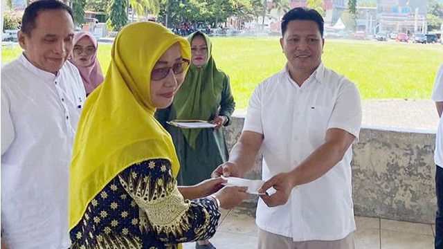Wakil Bupati Bolaang Mongondow, Dony Lumenta (kanan), menyerahkan bantuan pribadi kepada BAZNAS, untuk kemudian disalurkan ke warga tak mampu.