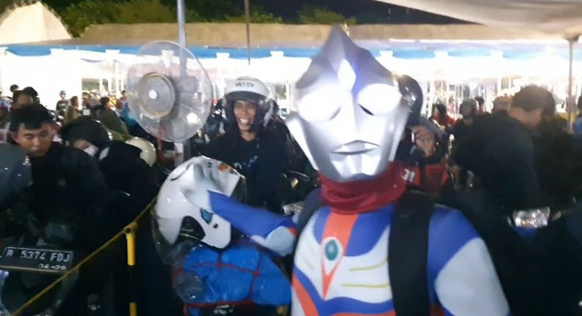 Pemudik asal Jakarta nekat mudik pakai motor mengenakan kostum Ultraman di Pelabuhan Ciwandan, Kota Cilegon, Banten, Sabtu (29/3) subuh. Foto: Dok.kumparan