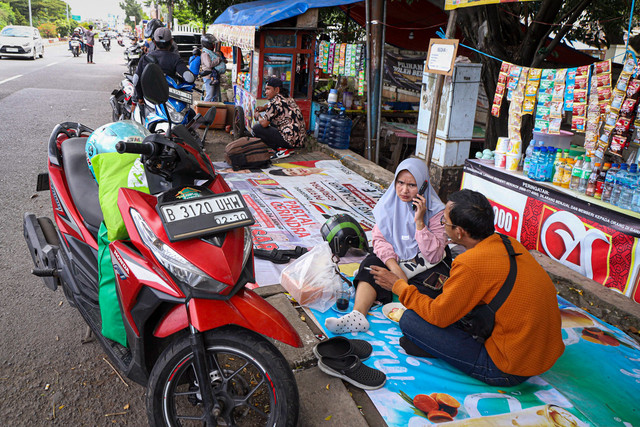 Pemudik beristirahat sambil menyantap hidangan yang ada di warung musiman pinggir jalan di kawasan Karawang, Jawa Barat, Sabtu (29/3/2025). 
 Foto: Iqbal Firdaus/kumparan
