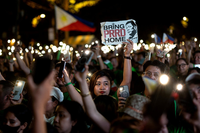 Para pendukung mantan Presiden Filipina Rodrigo Duterte memegang lilin dan telepon genggam yang menyala selama acara peringatan ulang tahun yang ke-80 Duterte di kota Davao City, Filipina, Jumat (28/3/2025). Foto: Eloisa Lopez/REUTERS