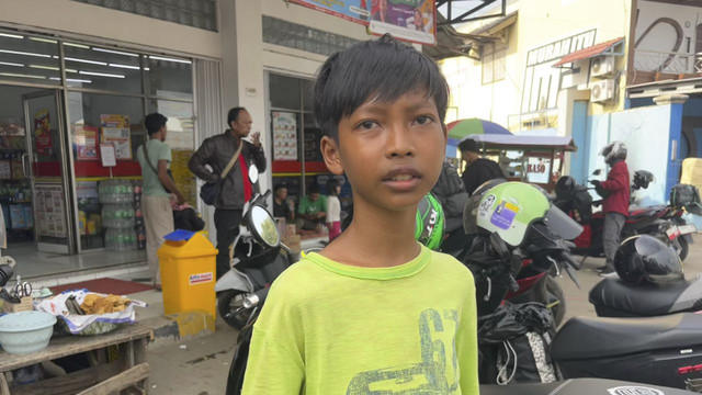 Seorang siswa kelas 1 SMPN 1 Lelea, Kabupaten Indramayu, Kevin (12) menjadi pengelap motor para pemudik untuk beli baju lebaran. Foto: kumparan