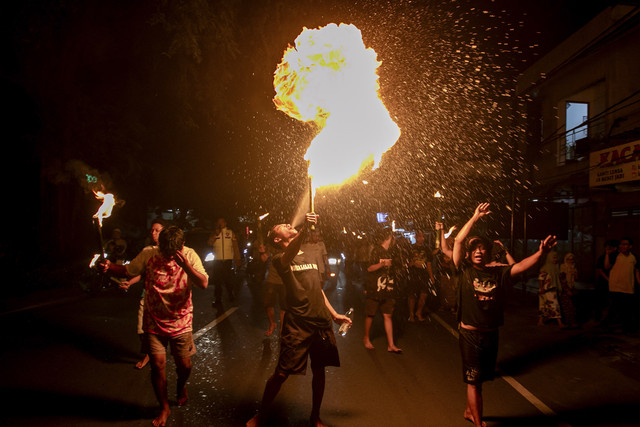 Warga menyemburkan api saat mengikuti pawai obor malam takbiran di Masjid Darussalam, Solo, Jawa Tengah, Minggu (30/3/2025). Foto: Mohammad Ayudha/ANTARA FOTO