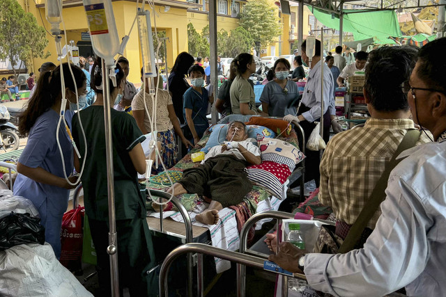 Seorang pasien terbaring di tempat tidur dikelilingi oleh para petugas medis di kompleks Rumah Sakit Umum Mandalay di Mandalay, Myanmar (31/3/2025). Foto: Sai Aung Main/AFP