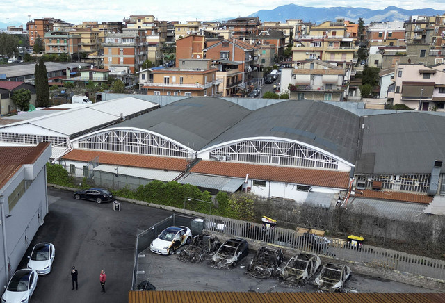 Foto udara menunjukkan kendaraan Tesla yang hangus setelah kebakaran di dealer Tesla yang menghancurkan kendaraan, di Roma, Italia, Senin (31/3/2025). Foto: Yara Nardi/REUTERS