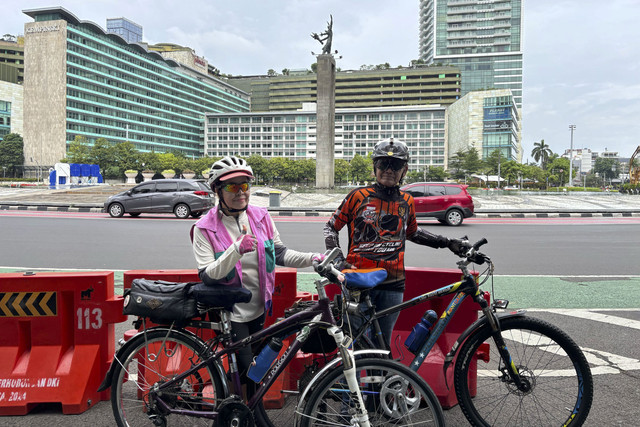 Warga Jakarta, Sugeng Santoso (75 tahun, kanan) beserta istrinya, di tengah bersepeda saat menikmati sepinya di Jakarta, Selasa (1/4/2025).  Foto: Abid Raihan/kumparan