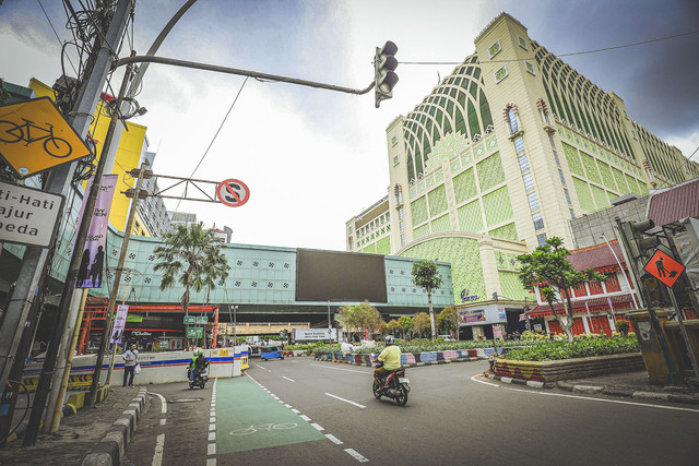 Seorang pengendara sepeda motor melintas di kawasan Pasar Tanah Abang, Jakarta. Foto: Jamal Ramadhan/kumparan