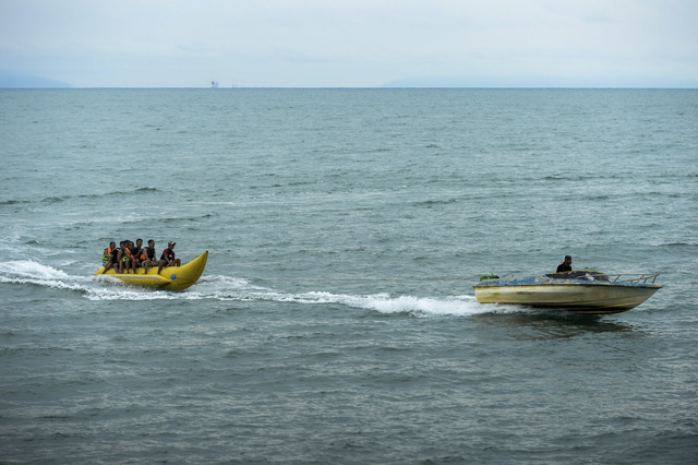 Wisatawan bermain perahu banana di Pantai Anyer, Kabupaten Serang, Banten, Selasa (1/4/2025). Foto: Muhammad Bagus Khoirunas/ANTARA FOTO