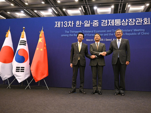 Ahn Duk-geun (tengah) sebagai Menteri Perdagangan, Industri, dan Energi Korea Selatan berjabat tangan bersama Menteri Ekonomi, Perdagangan, dan Industri Jepang, Yoji Muto (kiri), serta Menteri Perdagangan China, Wang Wentao, di Seoul. © Jung Yeon-je, AFP