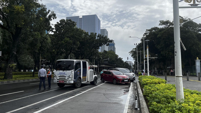 Sejumlah mobil yang parkir liar dikempesin dan ditindak pencabutan pentil akibat parkir liar di depan IRTI Monas,  Jakarta Pusat, Rabu (2/4/2025).  Foto: Rayyan Farhansyah/kumparan