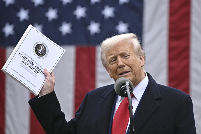 Presiden Donald Trump menunjukkan dokumen yang telah ditanda tangani mengenai tarif impor baru saat "Make America Wealthy Again" di Gedung Putih, Washington DC, Amerika Serikat, Rabu (2/4/2025). Foto: Brendan Smialowski/AFP