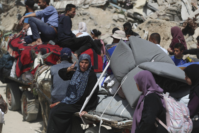 Seorang wanita Palestina membawa barang-barangnya saat ia dan warga lainnya meninggalkan rumah mereka di lingkungan Shujaiya, Kota Gaza, Kamis (3/4/2025). Foto: Mahmoud Issa/REUTERS