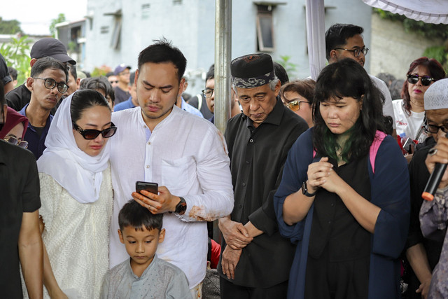 Anak dari aktor Ray Sahetapy, Rama Sahetapy (ketiga kiri) bersama istri Merdi Octav (kiri) menangis saat pemakaman aktor Ray Sahetapy di TPU Tanah Kusir, Jakarta, Jumat (4/4/2025). Foto: Jamal Ramadhan/kumparan