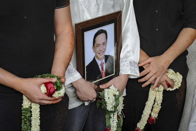 Soerang perwakilan keluarga membawa bingkai foto dan berdoa saat pemakaman aktor Ray Sahetapy di TPU Tanah Kusir, Jakarta, Jumat (4/4/2025). Foto: Jamal Ramadhan/kumparan