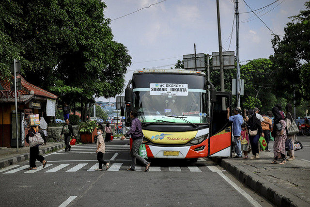 Sejumlah penumpang turun dari bus Antar Kota Antar Provinsi (AKAP) di Terminal Kampung Rambutan, Jakarta, Sabtu (5/4/2025). Foto: Jamal Ramadhan/kumparan