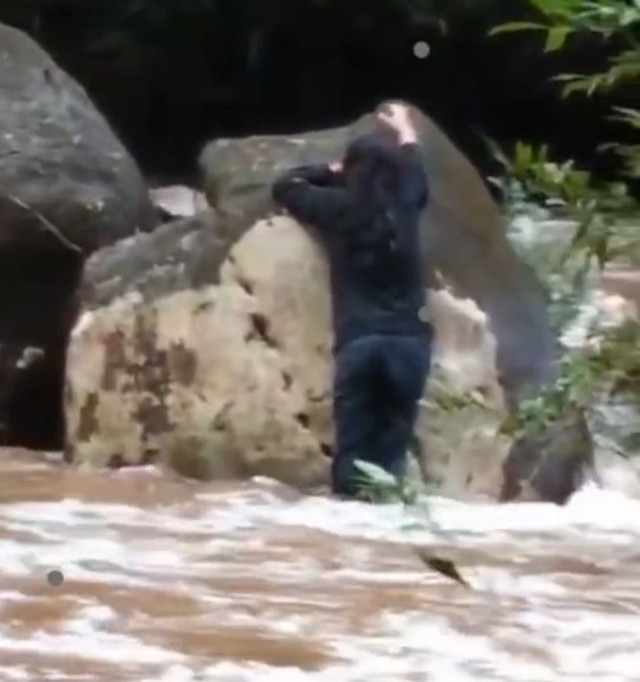 Korban yang selamat saat berpegangan di bebatuan menunggu evakuasi dari warga. Foto: Dok. instagram @sambasinformasi