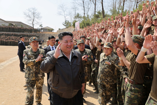 Pemimpin Korea Utara Kim Jong-un menyapa pasukan militer saat mengunjungi pangkalan pelatihan militer di Korea Utara, Jumat (4/7/2025). Foto: KCNA/via REUTERS