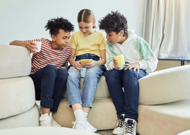 Ilustrasi anak-anak menggunakan media sosial. Sumber: https://www.pexels.com/id-id/foto/t-shirt-crew-neck-bergaris-garis-merah-putih-duduk-di-sofa-putih-7869451/