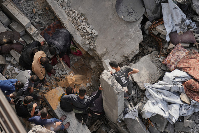 Warga Palestina memeriksa lokasi yang terkena serangan Israel di Deir al-Balah, Jalur Gaza, Senin (7/4/2025). Foto: Abdel Kareem Hana/AP PHOTO