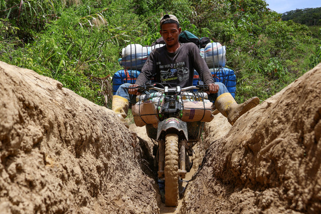 Tukang ojek mengangkut barang melewati jalanan tanah di Kecamatan Seko, Kabupaten Luwu Utara, Sulawesi Selatan, Selasa (8/4/2025). Foto: Arnas Padda/ANTARA FOTO