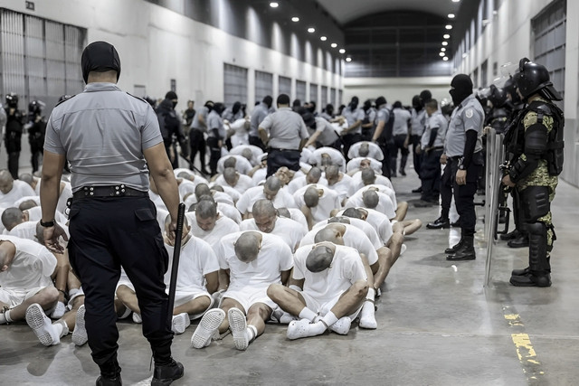 in this image released by the press office of the presidency of El Salvador, a prison officer is seen moving a detainee deported from the United States suspected of being a Venezuelan gang member to the Terrorism Detention Center located in Tecoluca, El Salvador (Source: Press Office of the Presidency of El Salvador via AP)