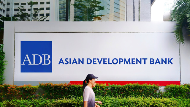 Warga melintasi gedung Asian Development Bank. Foto: Poetra.RH/Shutterstock