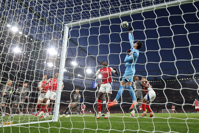 Kiper Real Madrid Thibaut Courtois meninju bola selama pertandingan leg pertama perempat final Liga Champions UEFA antara Arsenal dan Real Madrid, di Stadion Emirates, London, pada 8 April 2025. Foto: ADRIAN DENNIS / AFP