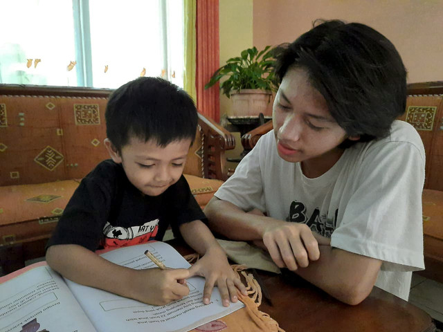 Seorang anak yang sedang belajar didampingi orang dewasa. ( SumberFoto : Ghefira Isyraq Kirana )