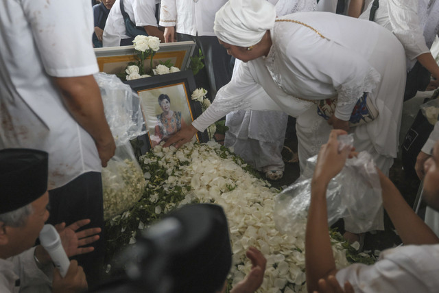 Sejumlah keluarga menaburkan bunga saat pemakaman pemeran film serta penyanyi Titiek Puspa di TPU Tanah Kusir, Jakarta, Jumat (11/4/2025). Foto: Agus Apriyanto