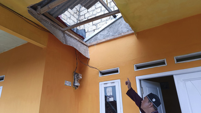 Heri (37), warga Kampung Buntar menunjukkan plafon teras rumahnya yang jebol karena gempa 4,1 m Kota Bogor, Sabtu (12/4/2025). Foto: Thomas Bosco/kumparan