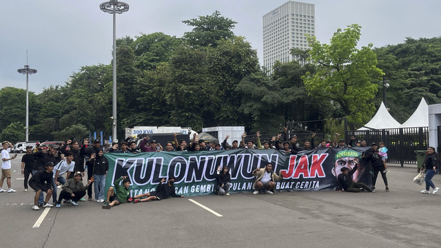 Sejumlah suporter Persebaya Surabaya, Bonek berpose dengan membentangkan spanduk sebelum menyaksikan laga Persija melawan Persebaya pada pertandingan BRI Liga 1 di Stadion Utama Gelora Bung Karno, Jakarta, Sabtu (12/4/2025). Foto: Azrumi El Ghazali/kumparan